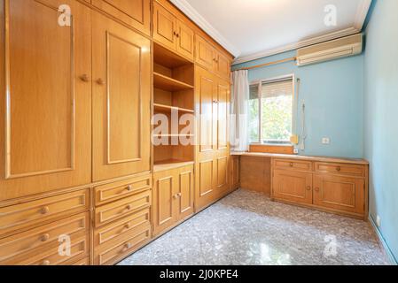 Jugendzimmer mit maßgefertigten Holzmöbeln mit Klappbetten, Schubladen und Regalen und blau gestrichenen Wänden Stockfoto