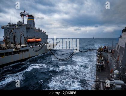 Der Lenkrakenzerstörer USS Delbert D. Black (DGG 119) erhält während eines Wiederauffüllens auf See während des Surface Warfare Advanced Tactical Training (SWATT) Treibstoff vom Nachschuböler USNS John Lenthall (T-AO-189). Delbert D. Black ist Teil von Destroyer Squadron (DESRON) 26, das die Carrier Strike Group (CSG) 10 unterstützt. SWATT wird vom Naval Surface and Mine Warfighting Development Center (SMWDC) geleitet und soll die Kampffähigkeit, Letalität und Interoperabilität der teilnehmenden Einheiten verbessern. (USA Navy Foto von Mass Communication Specialist 3. Class Bryan Vene Stockfoto