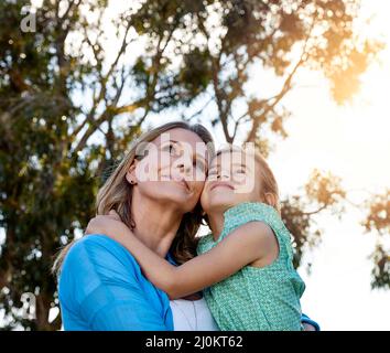 Das Leben ist alles eine Frage von Momenten. Aufnahme einer glücklichen Mutter und Tochter, die im Freien Zeit miteinander verbringen. Stockfoto