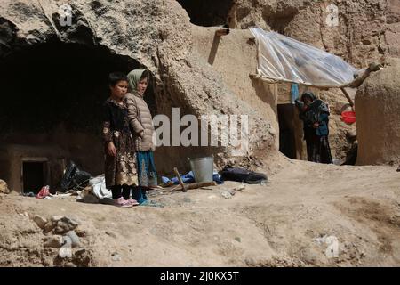 Bamiyan, Afghanistan. 19. März 2022. Afghanische Kinder werden in der Nähe der Höhlen gesehen, in denen sie in der Provinz Bamiyan, Afghanistan, leben, 19. März 2022. Quelle: Saifurahman Safi/Xinhua/Alamy Live News Stockfoto