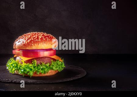Burger auf schwarzem Hintergrund mit Platz für Text. Rindersteak Stockfoto