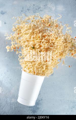 Ramen Tasse mit Instant-Nudeln fliegen aus ihm Stockfoto