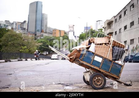 Transport des Mülles. Aufnahme eines Wagens voller Müll auf der Straße einer von Armut heimgesuchten Stadt. Stockfoto