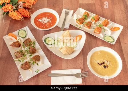 Typische indische Gerichte mit rotem, gelbem Korma, Kokosnuss, Gabeln, Kofta und gegrilltem Lammspieß Stockfoto