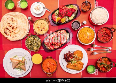 Bunte indische Speisenteller mit verschiedenen Currys, Naan, Palak Paneer, Lamm, Tandoori-Huhn, tikka Masala, Vorspeisen, Basmati-Reis, Falafel Stockfoto