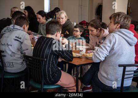 Lviv, Ukraine. 18. März 2022. Ukrainische Menschen, die aus ihren Häusern geflohen sind, essen in einem staatlich geführten Zentrum für Binnenvertriebene zu Mittag. Nach Angaben der Vereinten Nationen sind mehr als drei Millionen Ukrainer zu Flüchtlingen geworden und weitere zwei Millionen wurden intern vertrieben, seit Russland am 24. Februar 2022 mit der Invasion der Ukraine begann. (Foto: Laurel Chor/SOPA Images/Sipa USA) Quelle: SIPA USA/Alamy Live News Stockfoto