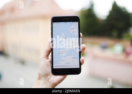 Mobiltelefon mit menschlicher Hand und GPS-Navigationsbildschirm Stockfoto