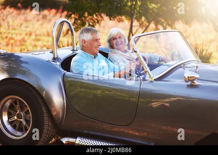 Eine Fahrt durch die Landschaft. Ausgeschnittene Aufnahme eines älteren Paares, das durch die Landschaft fährt. Stockfoto