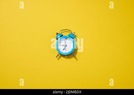 Runder weißer Wecker auf dem Tisch. Um sieben Uhr morgens, früh aufstehen Stockfoto