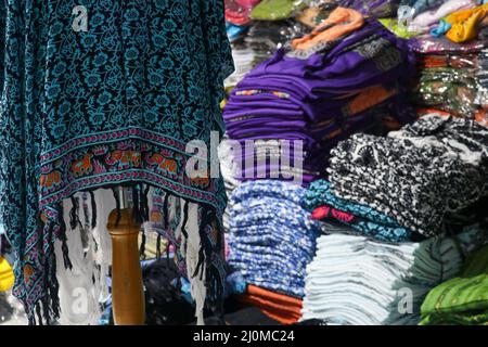 Pakete mit bunten Stoffen und Variationen von Batik-Sarongs in einem Geschäft auf einem traditionellen asiatischen Markt Stockfoto