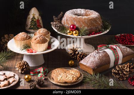 High-Angle-Sortiment weihnachtsdesserts mit Tannenzapfen roten Beeren Stockfoto