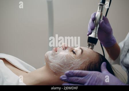 Junge Frau erhält eine elektrische RF-Lifting-Gesichtsmassage im Beauty-Spa mit Elektroporationsgeräten. Stockfoto