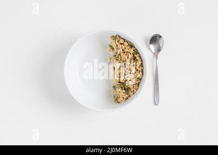 Müsli mit Kürbiskernen weißen Schüssel Löffel weißen Hintergrund Stockfoto