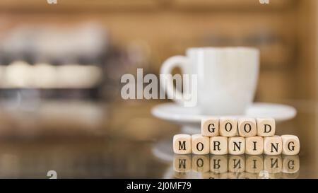 Good Morning kubische Blöcke mit Tasse Kaffee Reflexion Glas Stockfoto