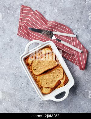 Brotpudding Frühstücksauflauf aus Weizenbrot, Eiern, Milch und geriebenen Äpfeln Stockfoto