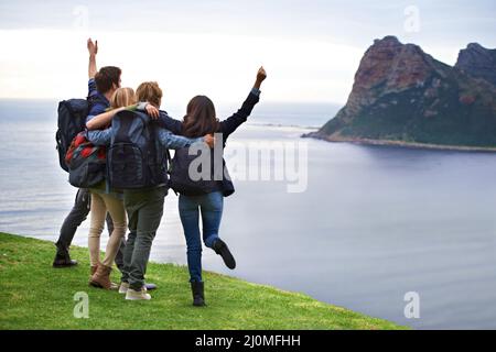 Spaß und Spannung im Urlaub. Eine Gruppe junger Menschen, die die Aussicht gemeinsam bewundern. Stockfoto