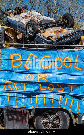 „Be Cool or Get Lost!“ Graffiti auf dem Schulbus Friedhof in Alto, Georgia. (USA) Stockfoto