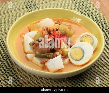 Lontong Sayur, Indonesische Küche. Komprimierter Reiskuchen oder Lontong mit Chayote und langen Bohnen in Kokosmilch und Gewürzen gekocht. Nahaufnahme Stockfoto