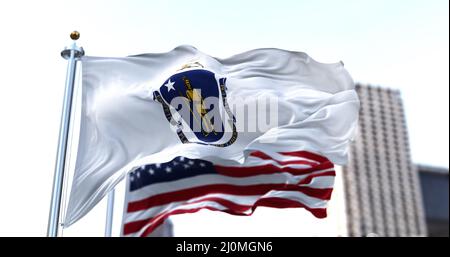 Die Flagge des US-Bundesstaates Massachusetts winkt im Wind, die amerikanische Flagge verschwimmt im Hintergrund Stockfoto