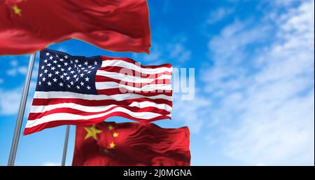 Die Nationalflagge der Vereinigten Staaten winkt zwischen zwei Flaggen Chinas mit klarem Himmel im Hintergrund Stockfoto