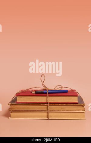 Ein Stapel zerschmetterter Bücher, gefesselt mit einem Juteseil und einem Füller Stockfoto