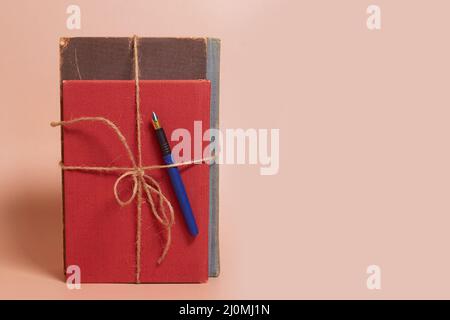 Ein Stapel zerschmetterter Bücher, gefesselt mit einem Juteseil und einem Füller Stockfoto