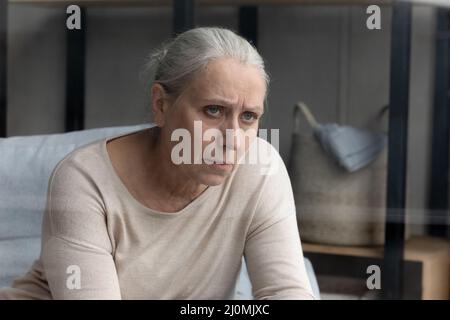 Pessimistisch gealterte Frau, die an einer senilen Krankheit leidet, sieht unglücklich aus Stockfoto