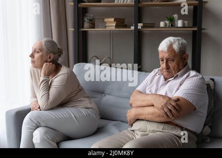 Ältere Paare sitzen getrennt auf dem Sofa Denken Sie an Beziehungsprobleme Stockfoto