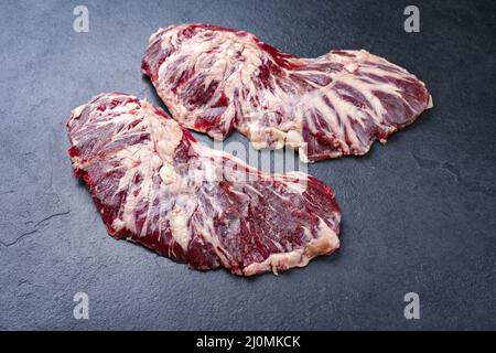 RAW Wagyu Spider Beef Steak als Draufsicht auf einem schwarzen Brett mit Kopierfläche angeboten Stockfoto