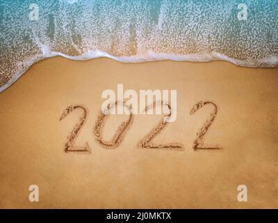 Frohes neues Jahr 2022, Schriftzug am Strand mit Welle und blauem Meer. Zahlen 2022 Jahr an der Küste, Neujahrs-Konzept. Stockfoto