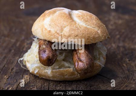 Nürnberger Würstchen mit Sauerkraut in einer Rolle Stockfoto