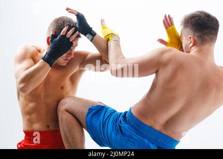 Zwei Männer Boxer kämpfen muay thai kniekniekick Boxen weißen Hintergrund. Stockfoto
