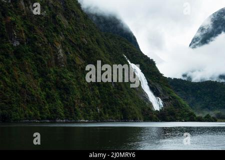 Lady Bowen fällt im Milford Sound mit Wolken, die in den Bergen, South Island, driften. Stockfoto