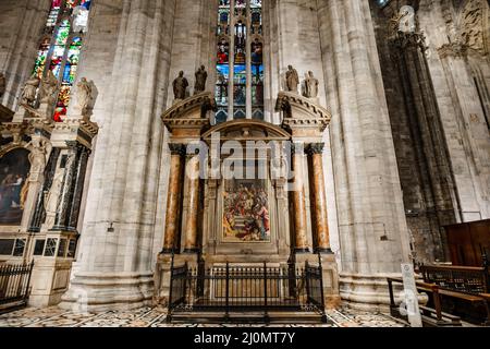 Fresko zwischen den Säulen unter einem Buntglasfenster im Dom. Mailand, Italien Stockfoto