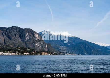 Stadt Tremezzo vor dem Hintergrund schneebedeckter Berggipfel. Italien, Comer See Stockfoto