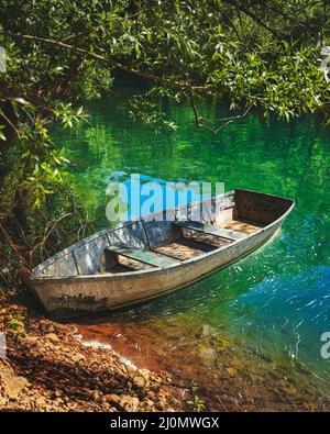 Altes Fischerboot am Ufer des smaragdgrünen Flusses Stockfoto