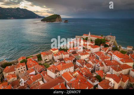 Luftaufnahme der Altstadt von Budva mit roten Dächern und dramatischen Wolken, Montenegro Stockfoto