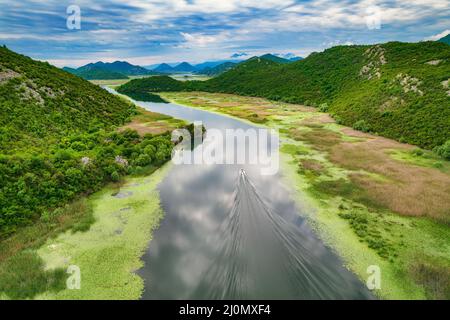 Boot in Skadar See mit erstaunlichen Wolken Reflexionen im Nationalpark in Montenegro, Luftaufnahme Stockfoto