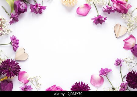 Verschiedene Blumen mit Holzherzen Tisch Stockfoto