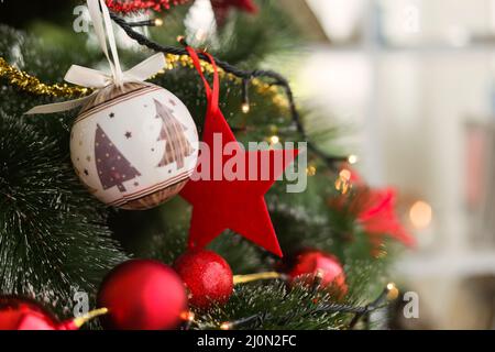 Weihnachtsbaum mit weihnachtskugeln und rotem Stern Stockfoto