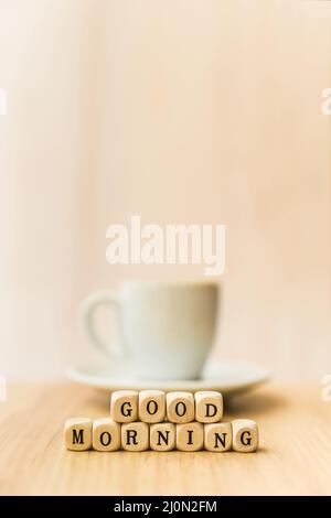 Nahaufnahme Guten Morgen kubische Blöcke mit Tasse Kaffee Holzfläche Stockfoto