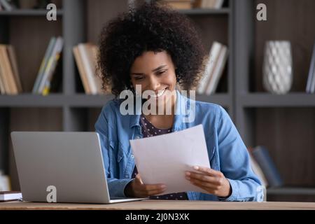 Zufriedenes Studentenmädchen, das von der Schule einen Brief zur Zulassung in Papierform erhalten hat Stockfoto