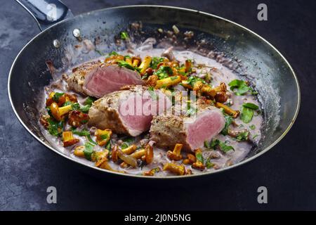 Gebratenes, trocken gealtertes Schweinefilet Chateaubriand Medaillon-Steak, natürlich mit Pfifferlingen in Walnusscreme-Sauce, serviert als Nahaufnahme in einem Stockfoto