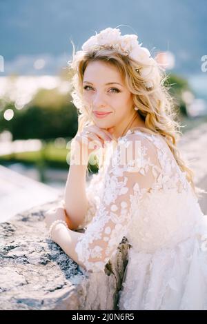 Schöne blonde lächelnde Braut in einem weißen Kranz, Nahaufnahme Stockfoto