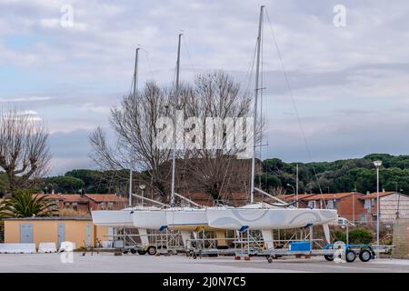 Auf einem Parkplatz in der Nähe des Hafens von Marina di Pisa, Italien, befinden sich vier Segelboote auf Anhängern Stockfoto