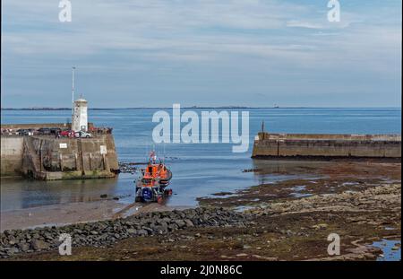 Das Shannon Class Lifeboat wird mit seinem getrackten Trägerrakete gestartet und nähert sich der Hafeneinfahrt bei Seahouses. Stockfoto