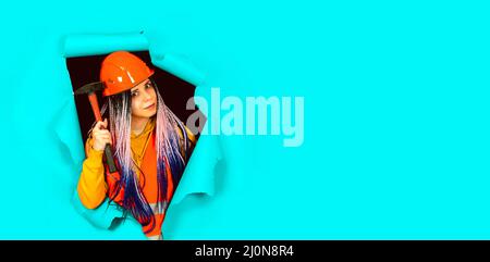Eine Frau in einem orangefarbenen Schutzhelm und einer Weste Stockfoto