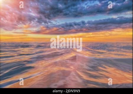 Bunte Wolken in der Morgendämmerung oder Dämmerung spiegeln sich in rauer See wider Stockfoto