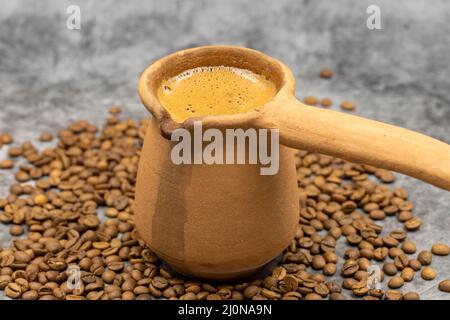 Türkischer Kaffee in einer irdenen Kanne auf dunklem Hintergrund. Nahaufnahme Stockfoto