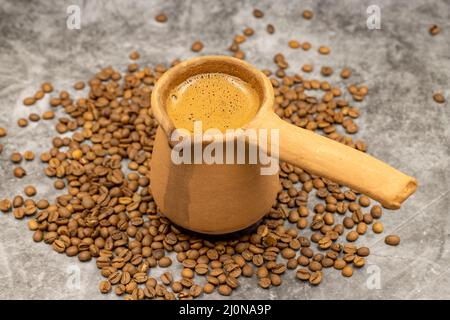 Türkischer Kaffee in einer irdenen Kanne auf dunklem Hintergrund. Nahaufnahme Stockfoto